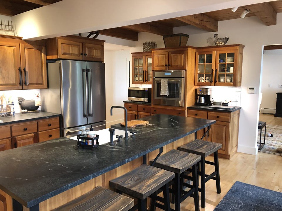 Kitchen has Thermador oven and cooktop, dishwasher, and soapstone countertops. 