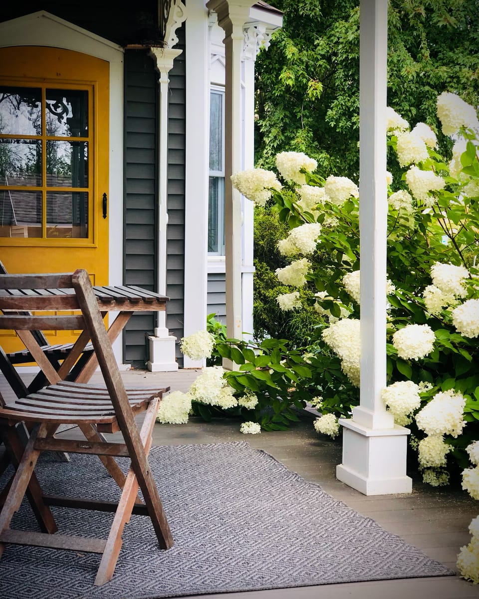 A cozy porch nook perfect for private convos, sips of coffee or a glass of wine!