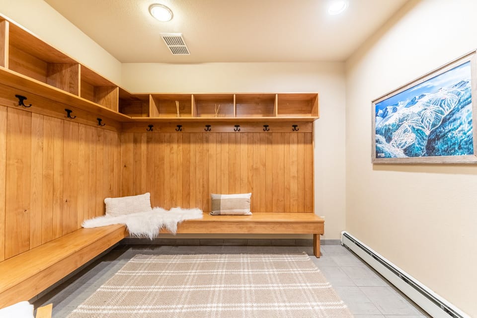 Settle into your private mudroom's warmth after mountain adventures, with custom storage cubbies for your gear and cozy seating.