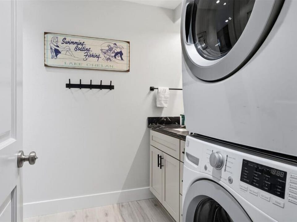 Your dedicated laundry area keeps vacation logistics simple, complete with a stacked washer-dryer combo, small countertop, and charming Lake Chelan decor reminding you of nearby adventures.