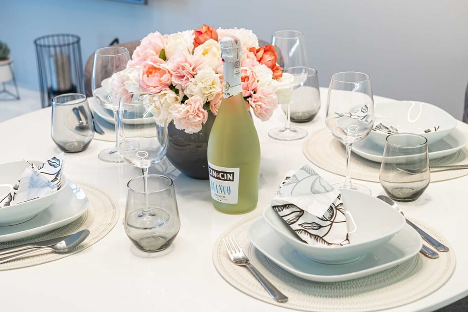 A dining table beautifully set with plates, glasses, and a decorative centerpiece.