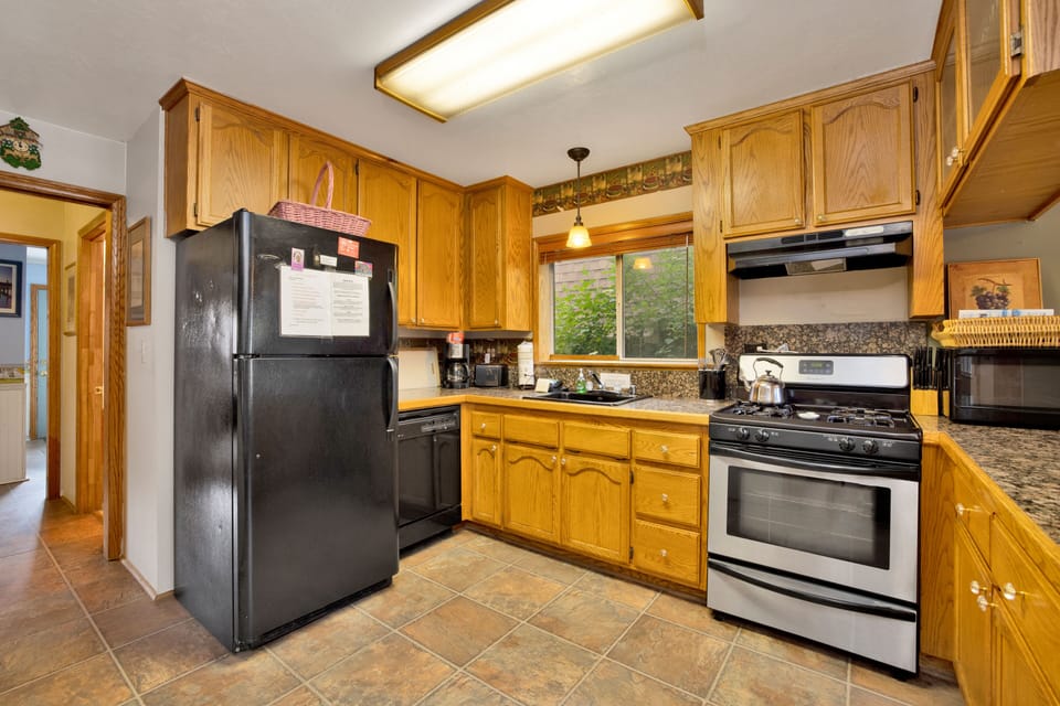 Fully equipped cabin kitchen with ample cabinetry, stove, fridge, microwave, and coffee maker—perfect for cooking meals, morning coffee, and feeling right at home on your stay.