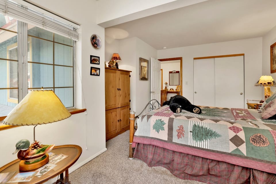 Peaceful cabin bedroom with plush bedding, and beautiful views—ideal for restful nights, cozy mornings, and a relaxing mountain escape.