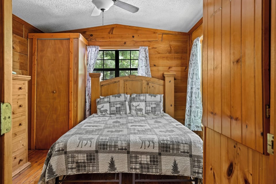Queen bed made for deep sleep—surrounded by knotty pine and nature’s quiet.