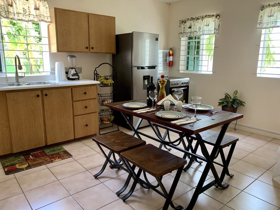 Full kitchen with breakfast table, fridge, stove and essential small appliances