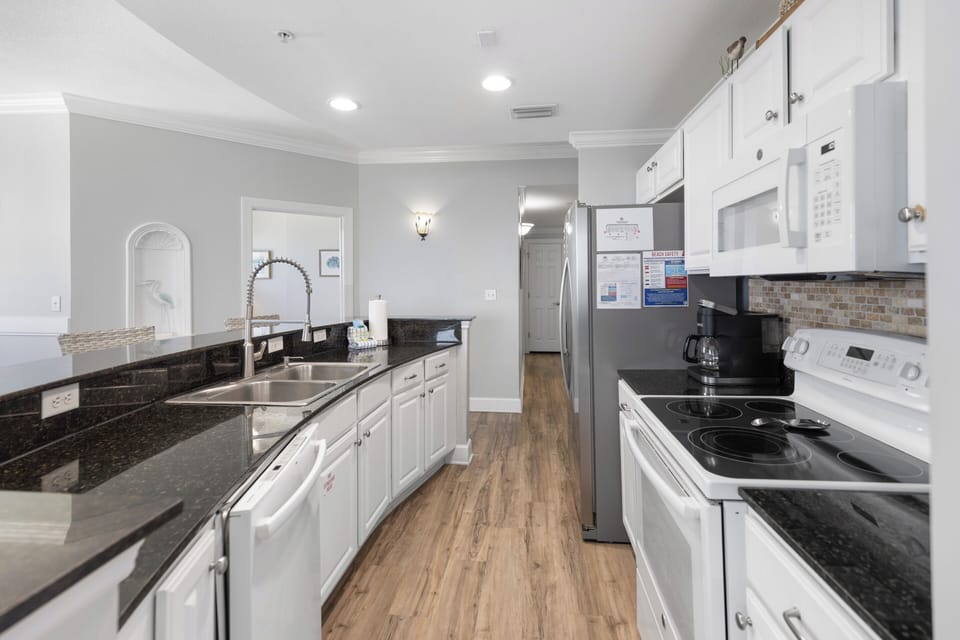 Your spacious kitchen blends modern convenience with elegant style—crisp white cabinetry, sleek granite counters, and stainless appliances await your culinary adventures.