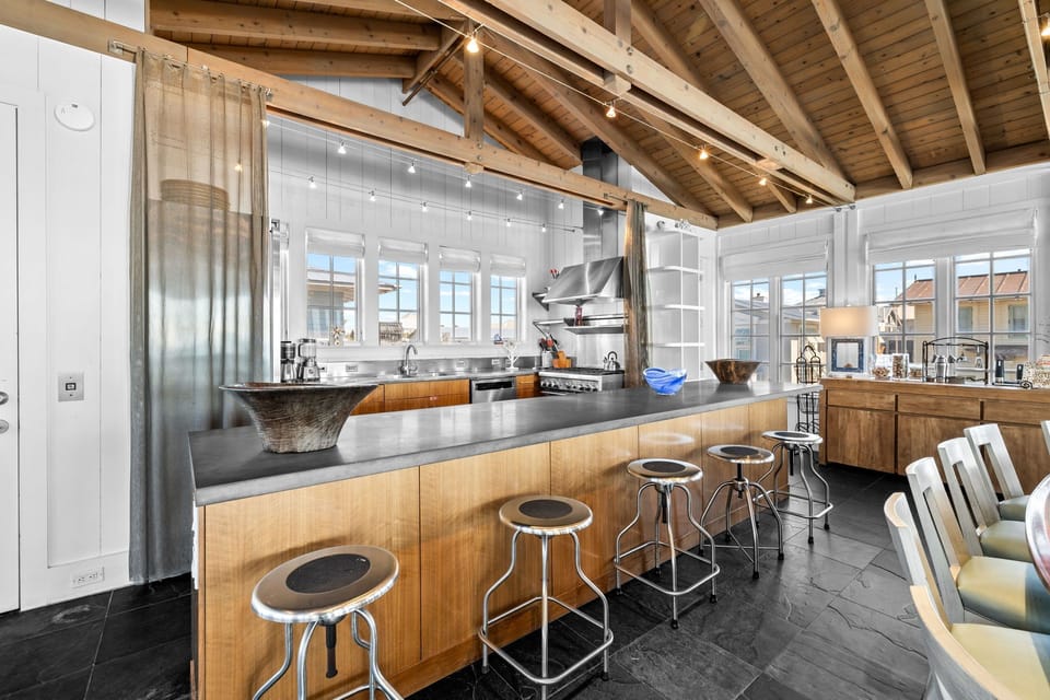 Chef's Kitchen with Natural Lighting, Luxury Concrete Island, and Exposed Wood Beam Ceilings
