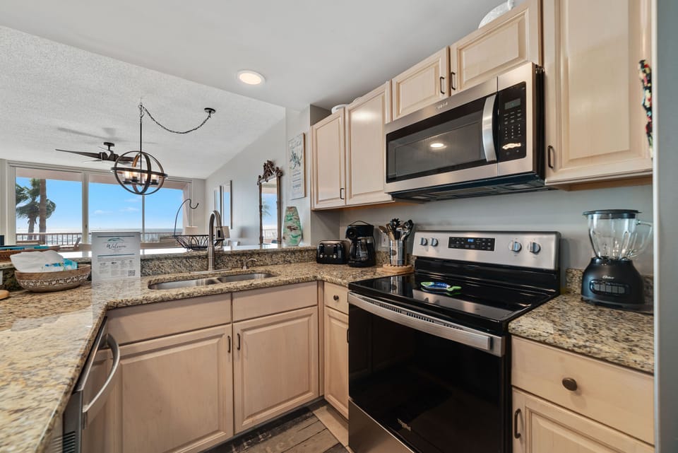 This fully functional kitchen boasts stainless steel appliances, sleek countertops, a decorative backsplash, and ample cabinet storage, ideal for everyday cooking and entertaining.