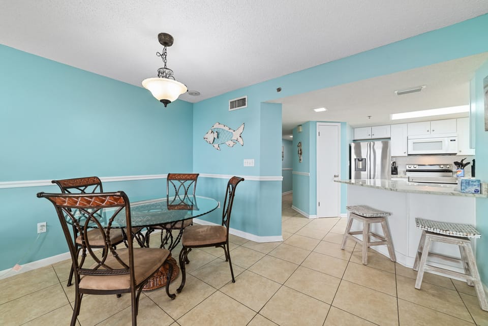 Seamless Entertaining. This bright, open kitchen features a large island with bar seating for 2 and flows directly into the elegant 4-seater dining table—perfect for family gatherings.