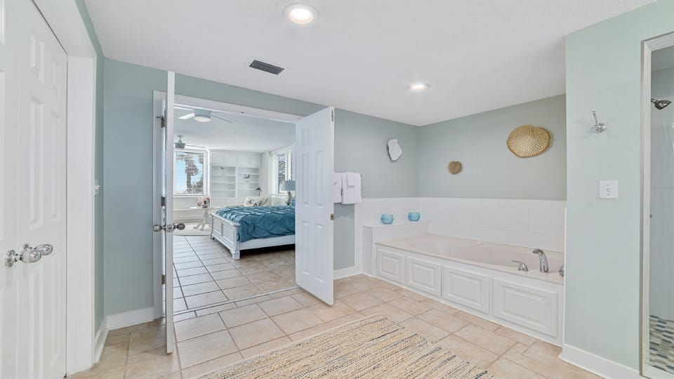 Discover this luxurious ensuite bathroom featuring a deep soaking tub, ample storage, and direct access to the primary bedroom.