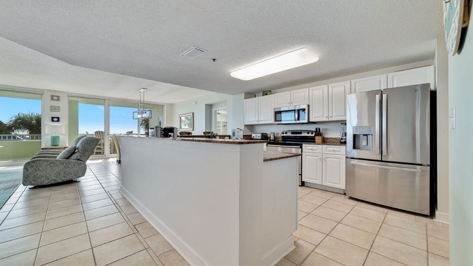 Discover this well-equipped kitchen featuring granite countertops, stainless steel appliances, and a seamless flow into the living area.