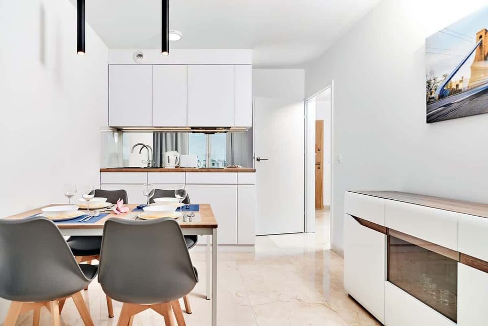 A contemporary kitchenette with white cabinets, wooden countertops, and a modern backsplash, perfectly suited for small spaces.
