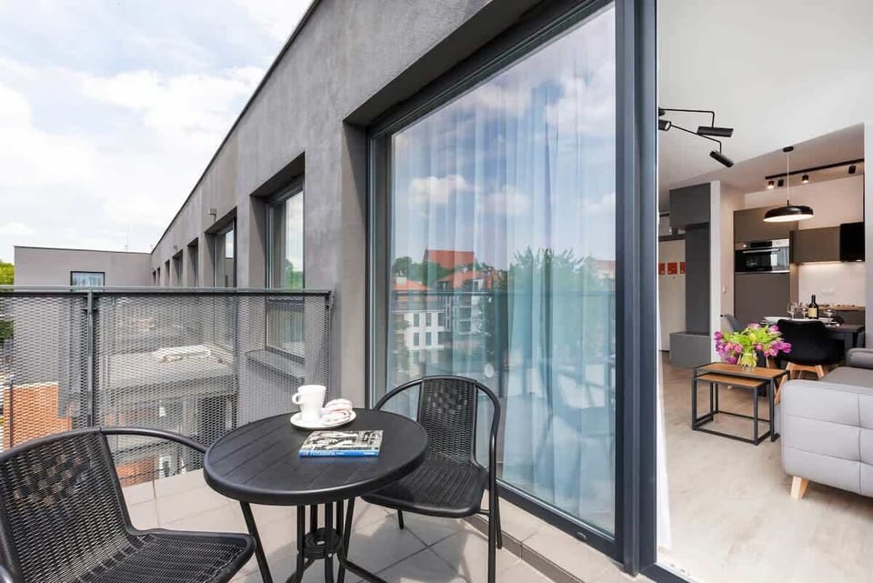 Spacious balcony with outdoor furniture. 