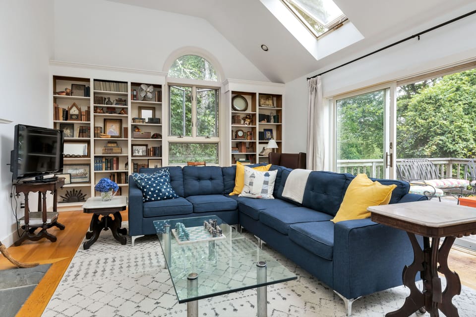 Living room with cathedral ceilings and Roku TV. Sliders open onto the deck.  