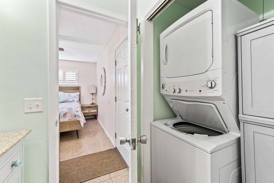 Laundry area with stackable washer and dryer in the master bathroom.