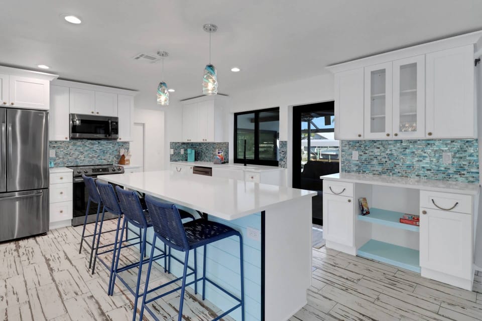 The open kitchen features a large island with seating for 4 and direct access to the lanai through slider door and pass through window.