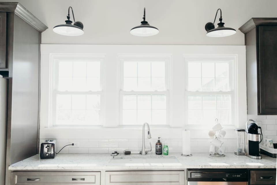 Large counter and sink overlooking fenced in back yard. 