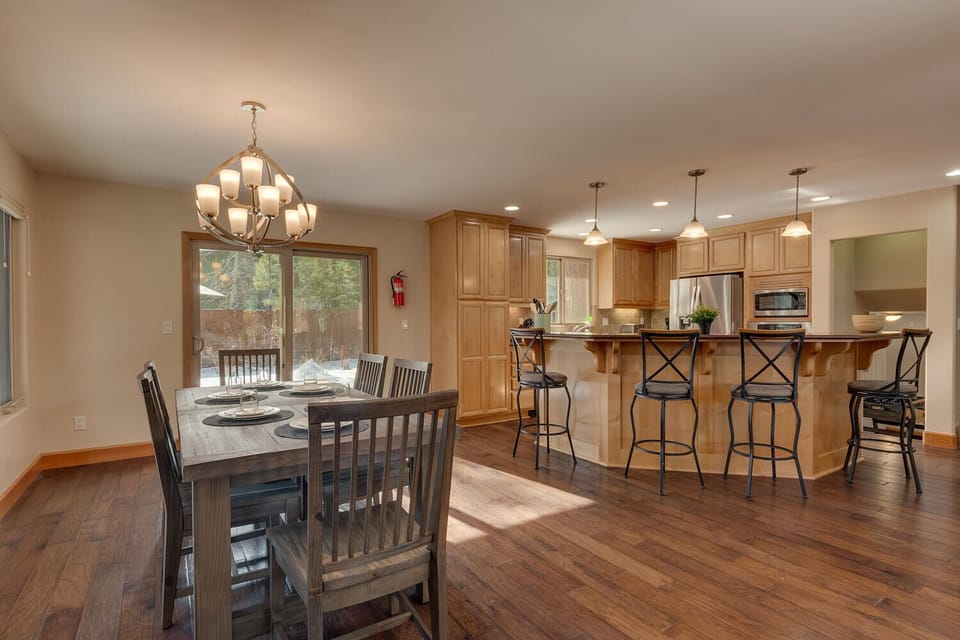- Bright dining area with natural sunlight views  
- Rustic wood table set for family and friends  
- Connected to kitchen for seamless group dining