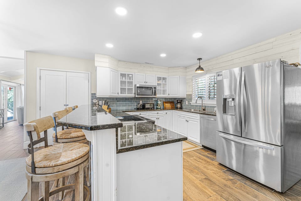 Renovated kitchen with granite countertops, tile backsplash and stainless steel appliances
