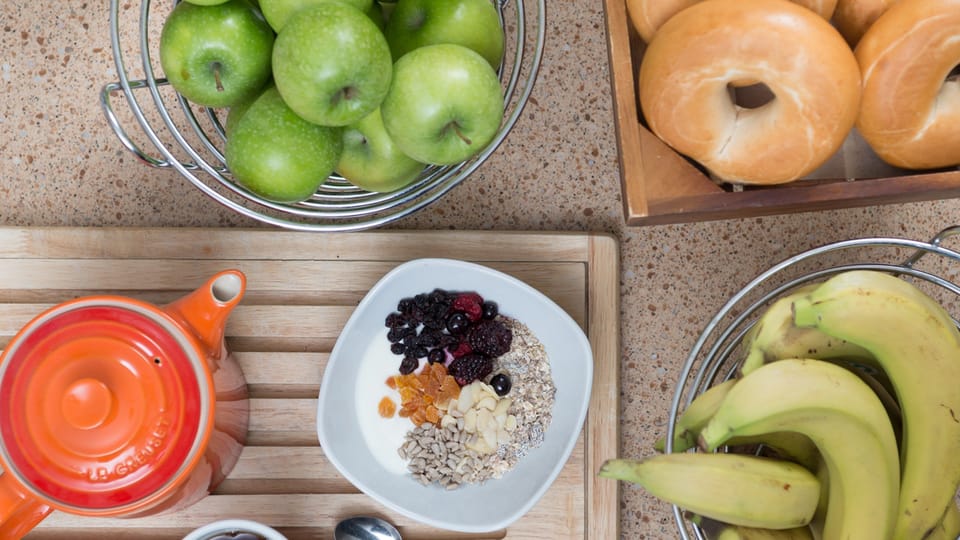 Breakfast display with fresh fruits and cereal bowl.