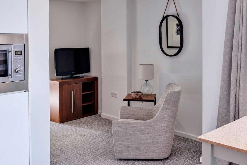 Cozy seating area with comfortable chair and flat-screen television.