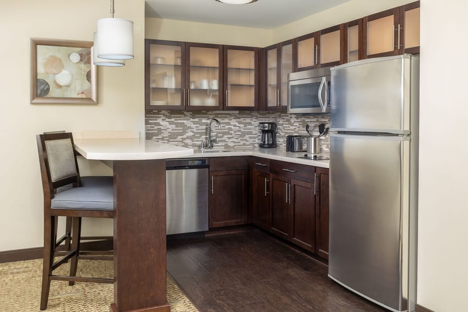 Kitchen with modern appliances and bar stools.