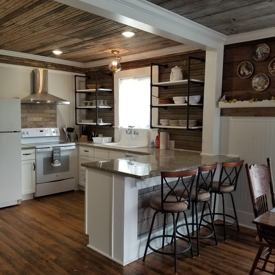 Kitchen has fridge with icemaker, dishwasher, glass top stove, island. 