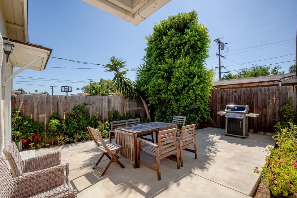 Backyard is fully fenced and private, with flowers and a nice tree for shade.  With Patio table & chairs, BBQ and additional seating.