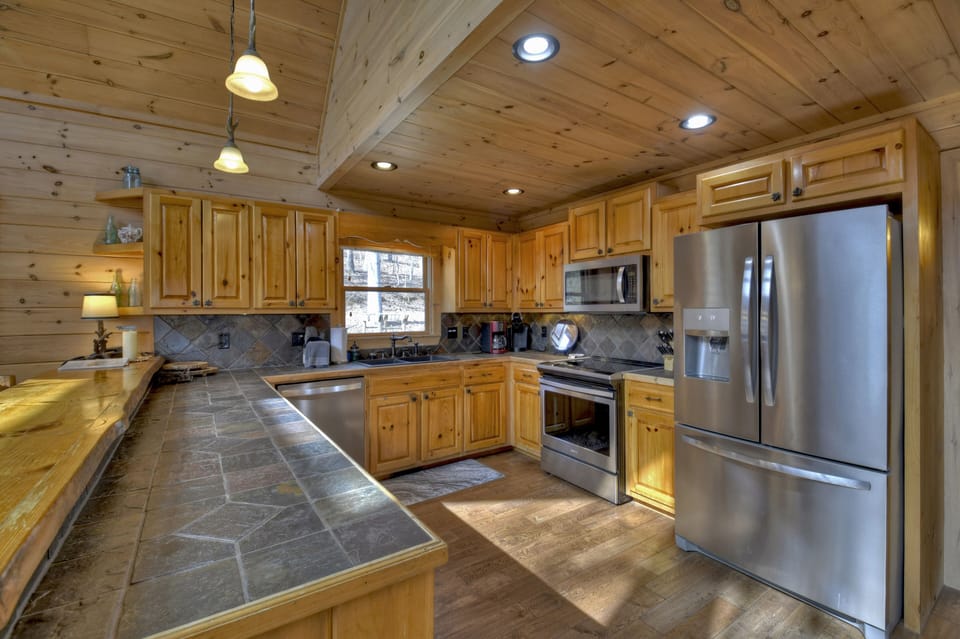 Spacious kitchen with new stainless appliances, slate counters and serving bar