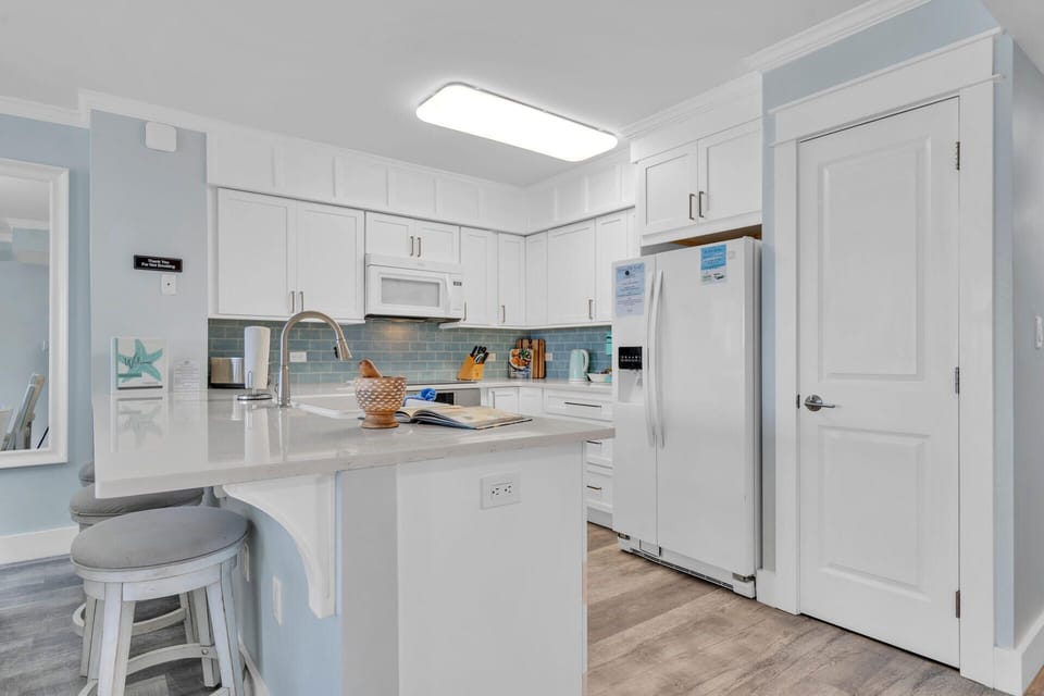 Your bright, fully-equipped kitchen awaits with modern appliances and coastal charm for memorable meal preparations.