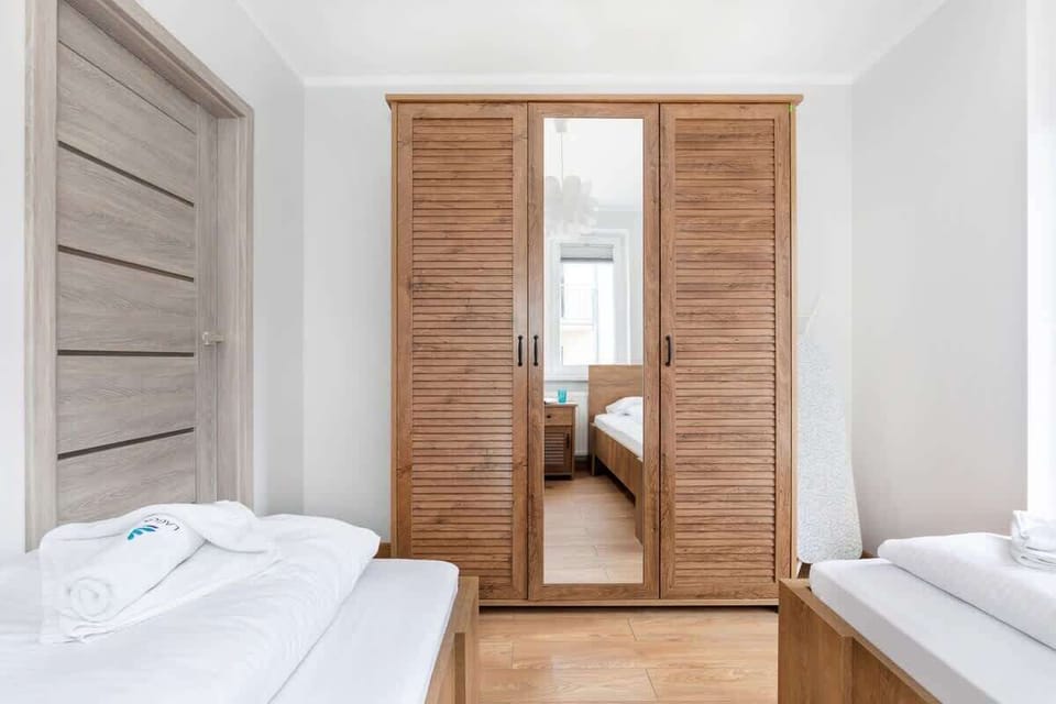 Bedroom with two single beds and closet with mirror.