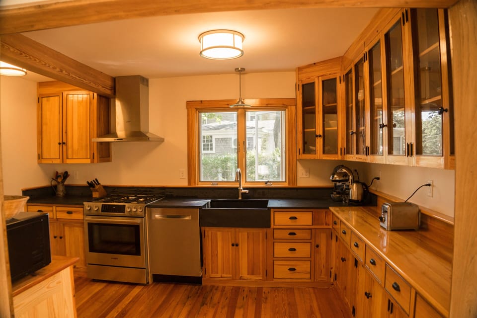 Kitchen with wooden cabinets, slate counters, and stainless appliances.