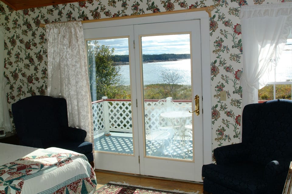 Bedroom 1 with cathedral ceiling and French doors open on to deck, en suite bath