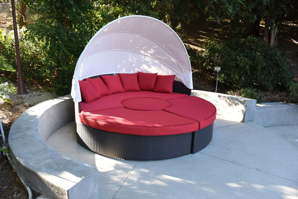 Day bed by the side of the pool. It has a canopy that can be lowered or raised. 