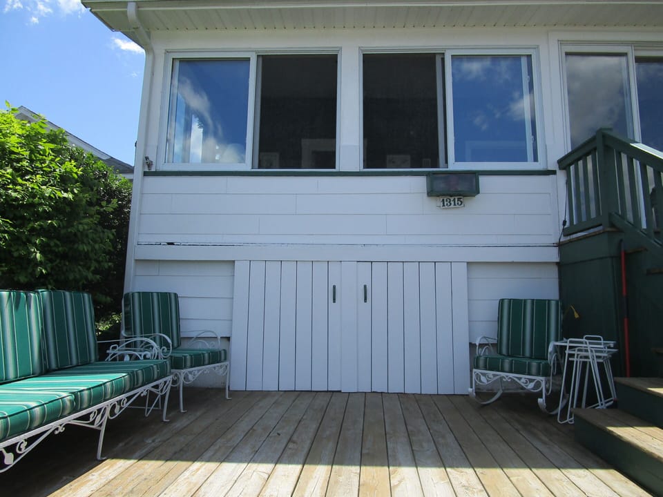Outdoor deck on lakeside, porch windows.