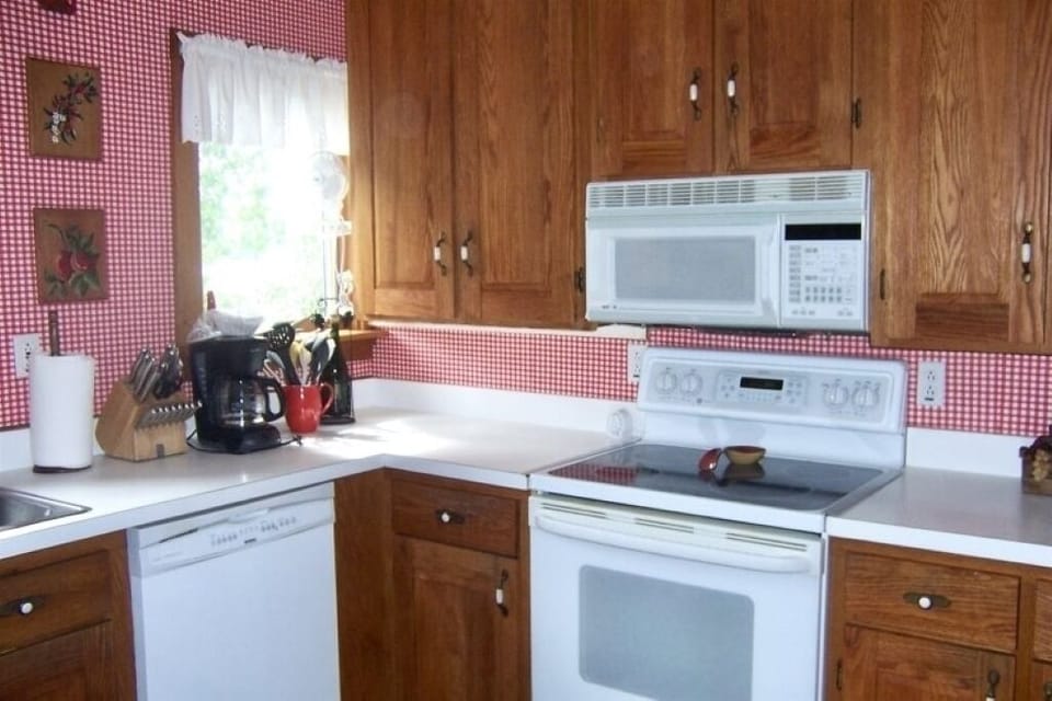 Kitchen with dishwasher, microwave and oven/range. Faces refrigerator.