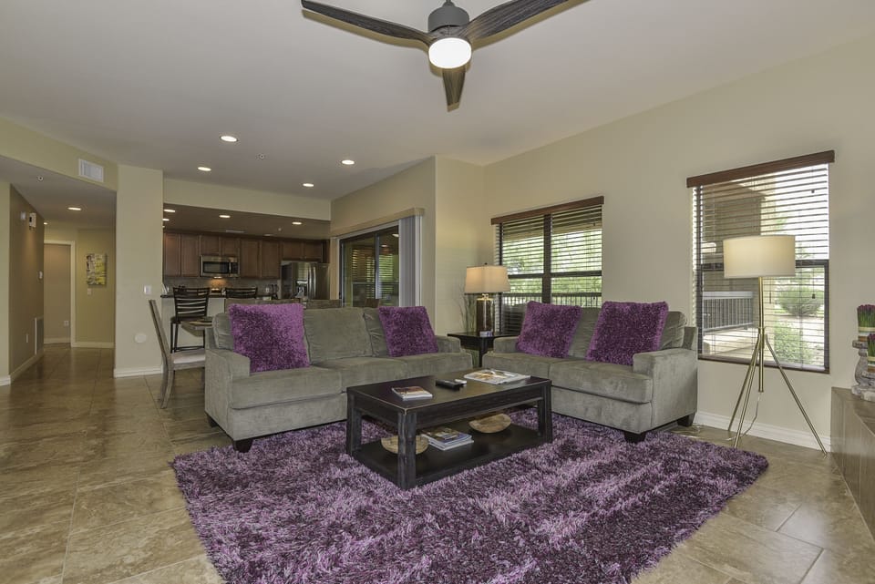 Stylish great-room opens to kitchen. Hallway leads to main suite and laundry.