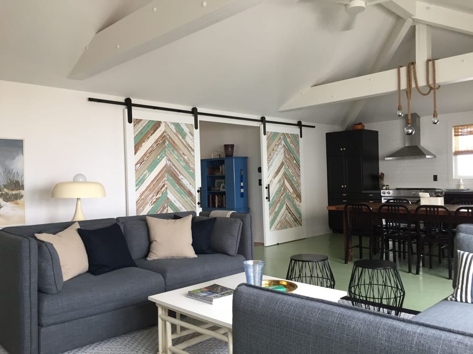 Living room, dining table and kitchen.  Barn doors close off bedroom hall.