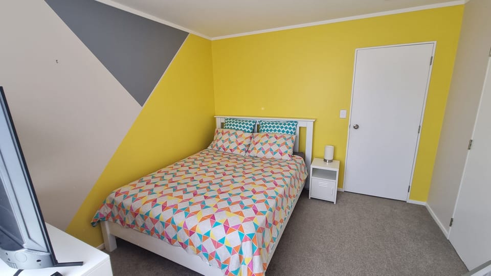 Bedroom 4 (Queen bed) with Smart TV and a small desk.