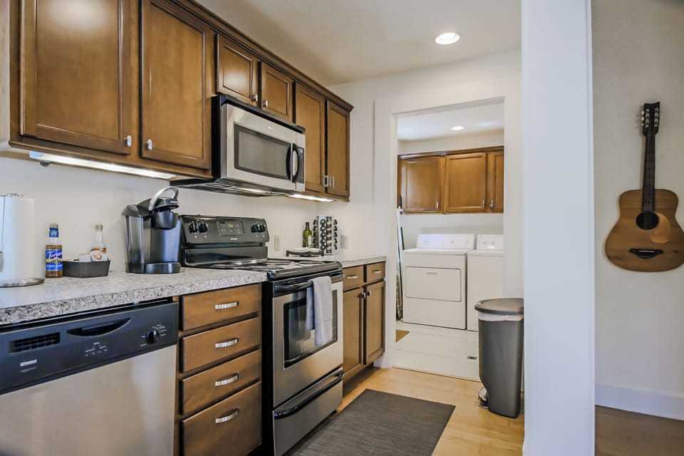 Fully outfitted kitchen, including stainless steel appliances and coffee maker.