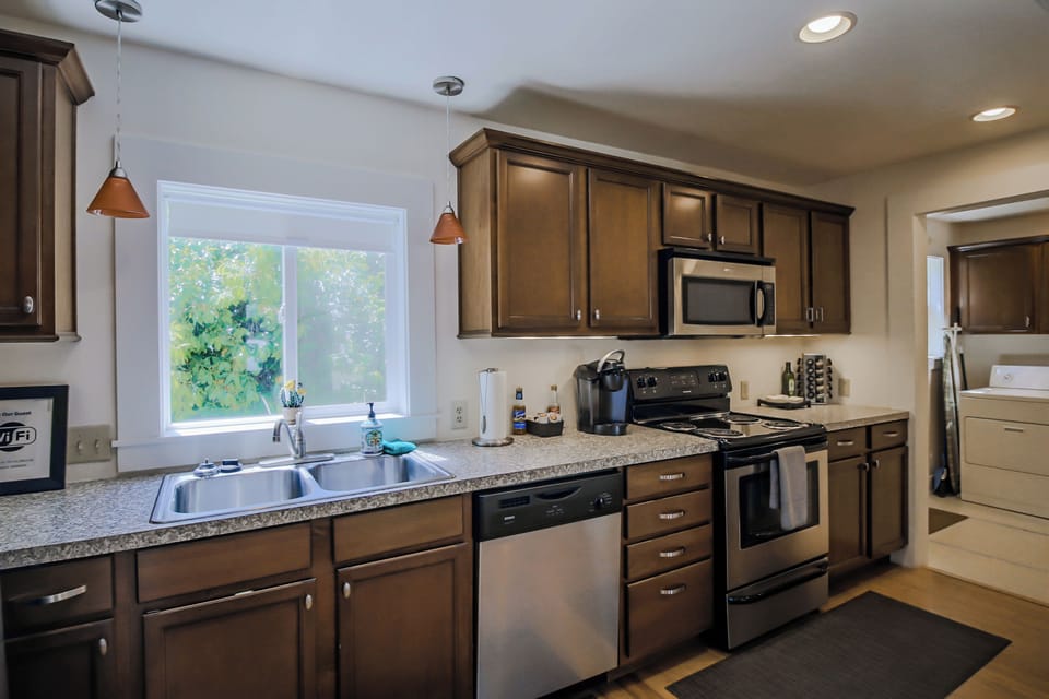 Rich kitchen cabinets with dinnerware, utensils, spices, oil, and pans.