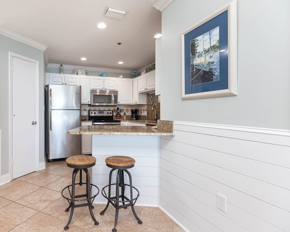 Gather around the stylish breakfast bar with two stools, perfect for casual meals in the inviting kitchen space