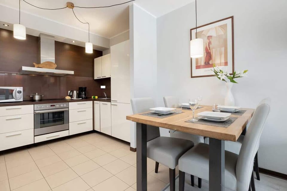Functional kitchenette with cupboards, dining area, stove, dishwasher, kettle, fridge, freezer, and toaster.