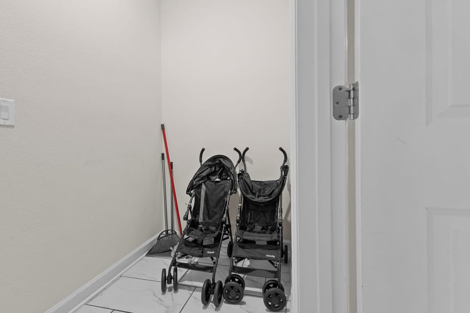 Your family gear has a dedicated spot - twin strollers and cleaning supplies stored safely in this convenient utility closet.