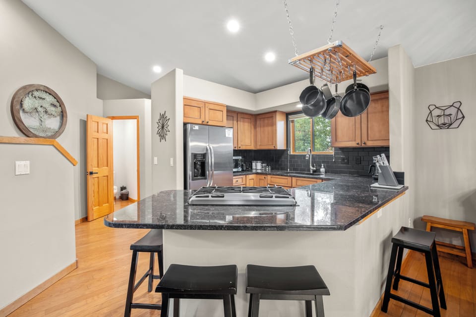 Stylish kitchen featuring sleek granite countertops, stainless steel appliances, and a spacious breakfast bar with seating. Perfect for preparing meals and entertaining guests.