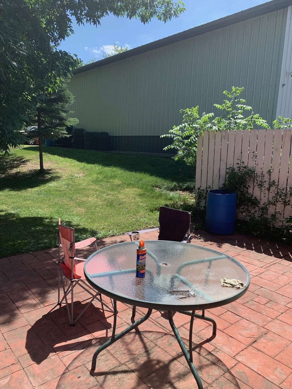 Exterior patio with table and several folding chairs.  (Beer or Coffee?)