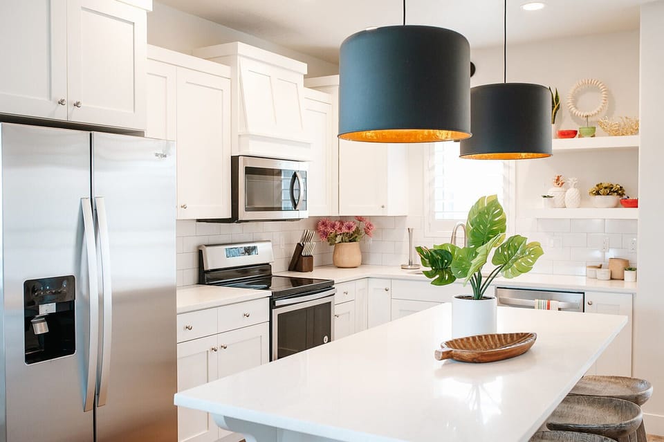 Cook and connect in the modern kitchen with stainless steel appliances, large island seating, and open layout — ideal for family stays near St. George.