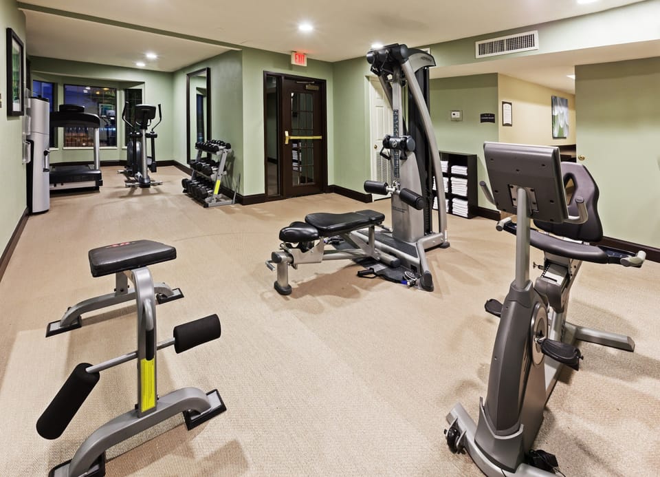 Fitness center with cardio equipment and wall-mounted monitor