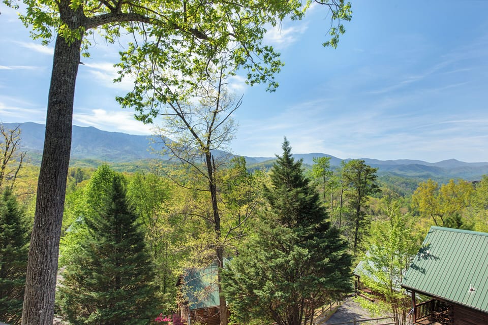 Breathtaking mountain views stretch across forested ridges from this elevated mountain retreat surrounded by towering trees.