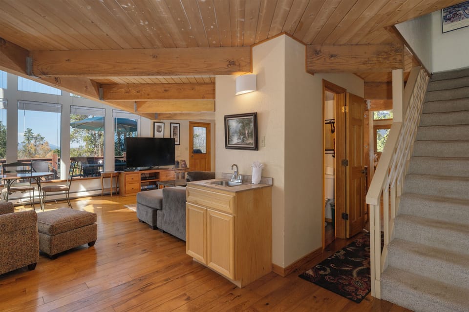Small hand sink located next to the living area, a powder room in the central hallway, and a staircase leading up to the secondary master.